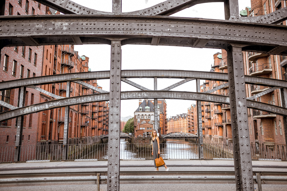 Eiserne Brücke mit Frau zu Fuß in der Speicherstadt, historisches Lagerhausviertel in Hamburg, Deutschland