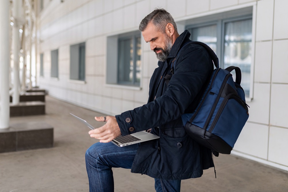 Geschäftsmann arbeitet am Laptop in der Flughafenlounge