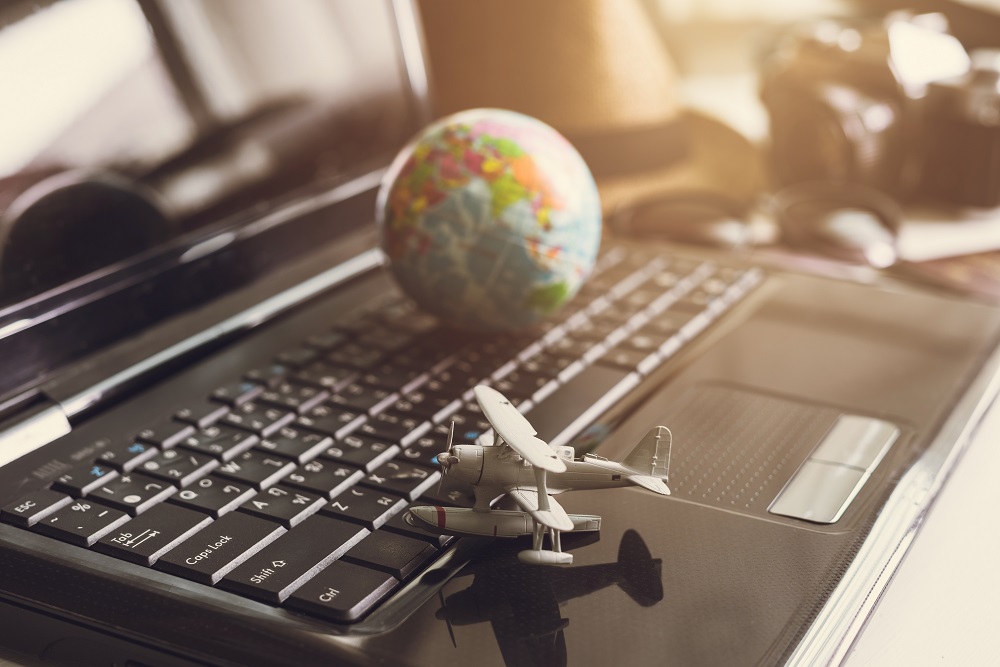 Globe on top of laptop with toy airplane