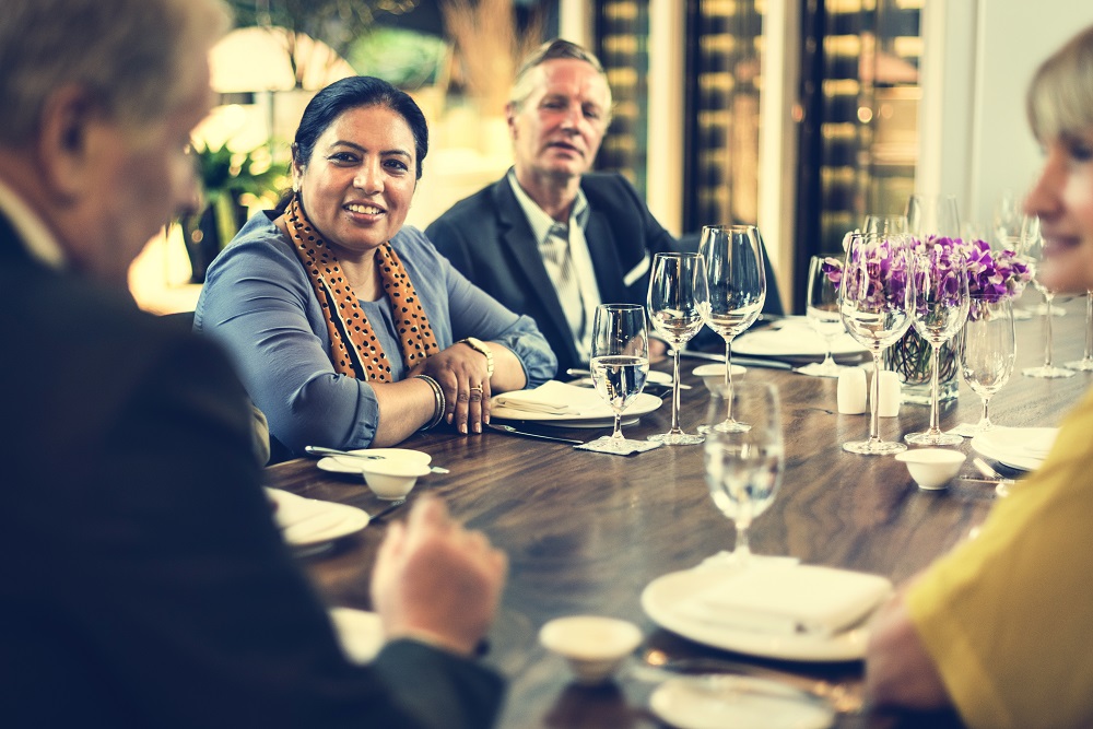 Multiracial table of business people having dinner