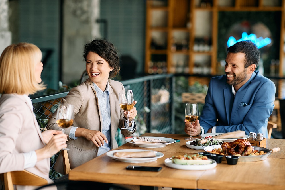 Business lunch of smiling coworkers with wine