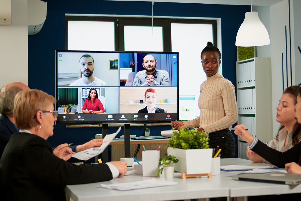 Hybrid meeting with woman leading in a conference room