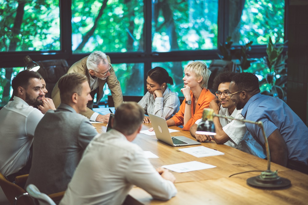 colleagues in a meeting room surrounded by trees