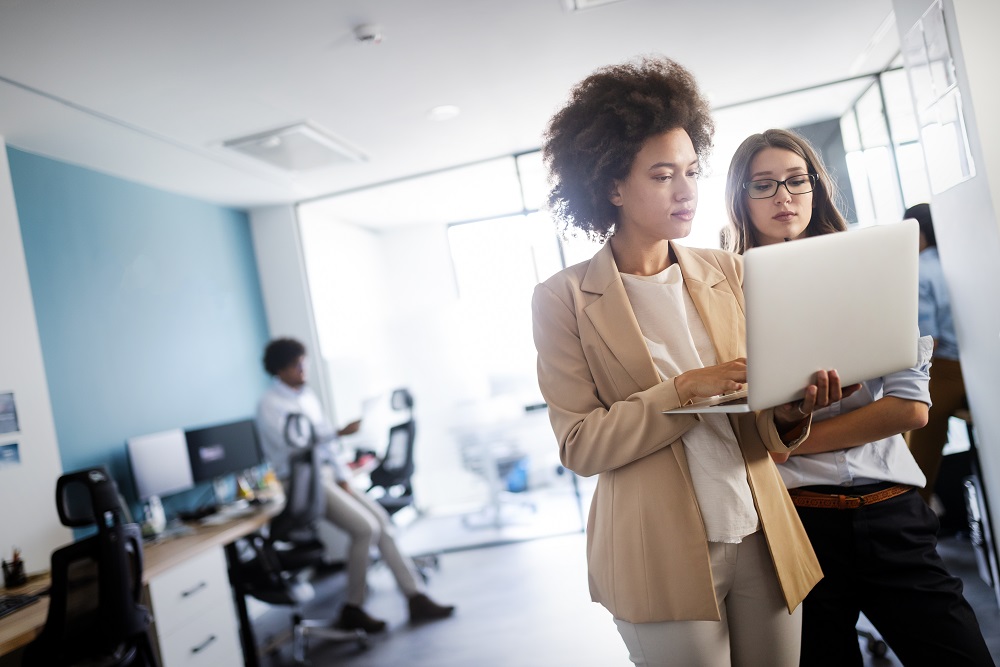 Two women looking at laptop in an office setting