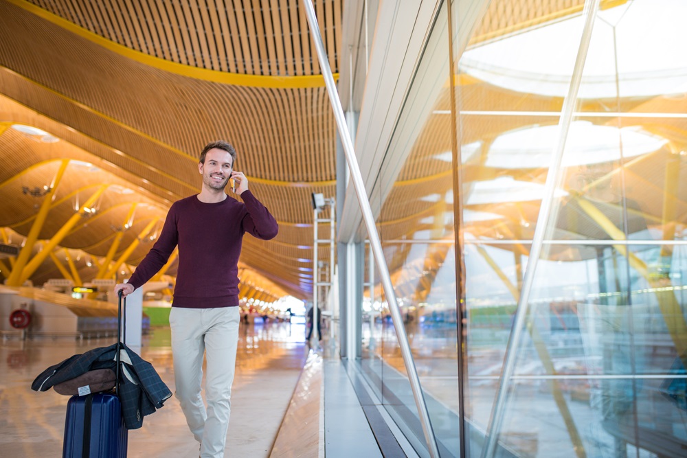 Frequent flyer walking through airporton the phone